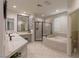 Spacious bathroom with dual vanity sinks, soaking tub, and glass shower perfect for luxurious self-care routines at 1301 Kingdom St, Las Vegas, NV 89117