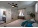 Bedroom featuring neutral colors, ceiling fan, plush bed, dresser and view to bath with updated vanity at 1301 Kingdom St, Las Vegas, NV 89117