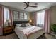 Bedroom featuring ceiling fan, plush bed with throw blanket, matching night stands and wall art at 1301 Kingdom St, Las Vegas, NV 89117