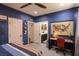 Comfortable bedroom with blue accent wall, desk, ceiling fan, and view to bath with updated vanity and ample natural light at 1301 Kingdom St, Las Vegas, NV 89117
