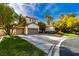 Spacious driveway leads to a three-car garage, complemented by mature landscaping and a blue sky backdrop at 1301 Kingdom St, Las Vegas, NV 89117