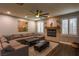 Spacious living room with a fireplace, a large sectional sofa, and a decorative ceiling fan at 1301 Kingdom St, Las Vegas, NV 89117