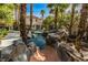 Resort-style pool featuring a rock waterfall, a waterslide, lush landscaping, and ample space for entertaining and relaxation at 1301 Kingdom St, Las Vegas, NV 89117