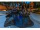 Tranquil pool featuring a rock waterfall, slide, and custom lighting creating a backyard paradise at 1301 Kingdom St, Las Vegas, NV 89117