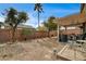 Large backyard featuring a covered patio, low maintenance desert landscaping, and secure brick fence at 2265 Stone Breeze Ave, North Las Vegas, NV 89031