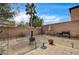 Spacious backyard with a brick wall, gravel landscaping, patio area, outdoor furniture, and a grill at 2265 Stone Breeze Ave, North Las Vegas, NV 89031
