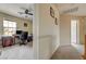 Hallway with neutral carpet leads to a home office with ceiling fan and natural light at 2265 Stone Breeze Ave, North Las Vegas, NV 89031