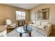 Inviting living room with a large window, cozy seating, and a decorative mirror at 2265 Stone Breeze Ave, North Las Vegas, NV 89031