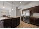 Kitchen with stainless steel refrigerator, dark cabinets, and light granite countertops at 260 Haley Way # 157, Mesquite, NV 89027