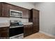 A kitchen featuring stainless steel appliances, dark wood cabinets, and granite countertops at 260 Haley Way # 157, Mesquite, NV 89027