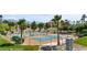 Community tennis courts surrounded by palm trees, lush landscaping, and scenic mountain views at 260 Haley Way # 157, Mesquite, NV 89027