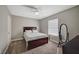 Bedroom with full sized bed, a window with blinds, a full length mirror, and neutral colored walls and carpet at 3823 S Maryland Pkwy # T8, Las Vegas, NV 89119