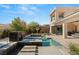 The luxurious pool features multiple levels of water, plus a seating area and lush backyard landscaping at 39 Coralwood Dr, Las Vegas, NV 89135