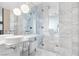 Elegant bathroom featuring dual sinks, marble countertops, a walk-in shower, and modern lighting at 4381 W Flamingo Rd # 38303, Las Vegas, NV 89103