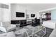 Modern living room featuring TVs, a workspace, and a view of the kitchen and the rest of the condo at 4381 W Flamingo Rd # 38303, Las Vegas, NV 89103