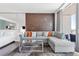Contemporary living area with gray sectional sofa, city view, and access to bedroom at 4381 W Flamingo Rd # 38303, Las Vegas, NV 89103