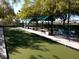 Community bocce ball court with shaded benches and lush green surface for recreational enjoyment at 4956 Momenti St, Las Vegas, NV 89135