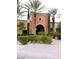 Community clubhouse entrance with stone archway, landscaping, and palm trees at 4956 Momenti St, Las Vegas, NV 89135