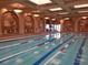 Indoor swimming pool with blue and white lane dividers, arched entryways, and muraled walls at 4956 Momenti St, Las Vegas, NV 89135