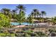 Community pool featuring palm trees, lounge chairs, and shade structures at 4956 Momenti St, Las Vegas, NV 89135
