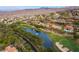 Overhead view of a community with a pond and golf course, complemented by luxurious homes and a desert landscape at 5 Circa De Montanas, Henderson, NV 89011