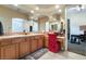 Large bathroom with dual sinks, ample counter space, and a red chair at the vanity at 5 Circa De Montanas, Henderson, NV 89011
