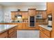 Kitchen with stainless steel appliances, granite countertops, and natural wood cabinetry at 5 Circa De Montanas, Henderson, NV 89011
