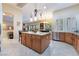 Kitchen island with marble countertop, wooden cabinets and stainless steel appliances at 5 Circa De Montanas, Henderson, NV 89011