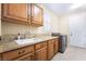 Well-equipped laundry room featuring granite countertops, wood cabinets, and modern washer and dryer at 5 Circa De Montanas, Henderson, NV 89011