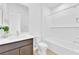 Bright bathroom with tub, shower, marble counter and brown cabinets at 5030 Sandline Court, Las Vegas, NV 89135