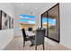 Stylish dining room with modern light fixture, tile flooring, and large windows with backyard views at 5030 Sandline Court, Las Vegas, NV 89135
