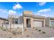 A modern one-story home featuring a stone facade, two-car garage, and desert landscaping at 5030 Sandline Court, Las Vegas, NV 89135
