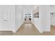 Bright hallway with white walls, tile flooring, and a view into the living area showcasing an open layout at 5030 Sandline Court, Las Vegas, NV 89135