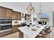 Modern kitchen with stainless steel appliances, a quartz countertop island, and dark wood cabinets at 5030 Sandline Court, Las Vegas, NV 89135
