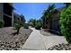 Scenic walkway lined with lush greenery and stone landscaping between condo buildings at 516 Sellers Pl, Henderson, NV 89011