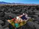 Find a pool, patio, and solar panels in this aerial view of this home and its backyard at 6129 Flaming Arrow Rd, North Las Vegas, NV 89031