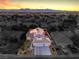 Aerial view of a home featuring a well-manicured lawn and a vibrant sunset in the background at 6129 Flaming Arrow Rd, North Las Vegas, NV 89031