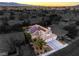 A dusk aerial view of a home with solar panels, a pool and well-manicured landscaping at 6129 Flaming Arrow Rd, North Las Vegas, NV 89031