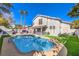 Gorgeous backyard showcasing a pool, outdoor kitchen and lush green grass at 6129 Flaming Arrow Rd, North Las Vegas, NV 89031