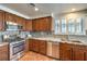 Well-lit kitchen featuring stainless steel appliances, granite countertops, wood cabinets, and a modern design at 6129 Flaming Arrow Rd, North Las Vegas, NV 89031