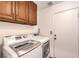 Laundry area with white front-load machines and overhead storage at 6129 Flaming Arrow Rd, North Las Vegas, NV 89031