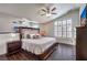 Relaxing main bedroom features a ceiling fan, plantation shutters, wood floors, and mirrored wall at 6129 Flaming Arrow Rd, North Las Vegas, NV 89031