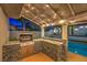Elegant outdoor kitchen with granite countertops, a built-in grill, and a view of the sparkling pool area at 6129 Flaming Arrow Rd, North Las Vegas, NV 89031