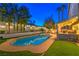 Beautiful backyard featuring a sparkling pool, hot tub, covered patio, built-in grill, and manicured lawn at 6129 Flaming Arrow Rd, North Las Vegas, NV 89031