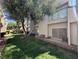 Backyard patio area with sliding door, lush green grass, mature tree, and space for seating at 6250 W Flamingo Rd # 143, Las Vegas, NV 89103