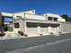 Condo with multiple attached garages, stairs, and landscaped surroundings under a clear blue sky at 6250 W Flamingo Rd # 143, Las Vegas, NV 89103