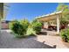 Outdoor area includes brick pavers, artificial grass, privacy shrubs, and a covered patio with comfortable outdoor furniture at 6656 Fort William St, North Las Vegas, NV 89084