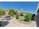 Backyard with brick pavers and outdoor seating area with a gas fire pit, grass, and landscaping, surrounded by a privacy wall at 6656 Fort William St, North Las Vegas, NV 89084