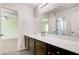 Bathroom vanity featuring white countertop, mirror, and dark cabinets at 6656 Fort William St, North Las Vegas, NV 89084