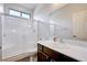 Bright bathroom featuring a shower with glass door and white cabinets at 6656 Fort William St, North Las Vegas, NV 89084